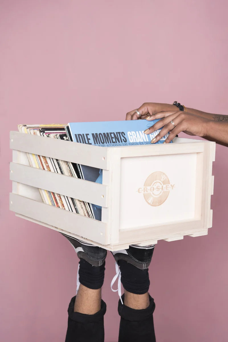 Crosley natural wood vinyl record storage crate displayed in a lifestyle setting
