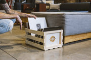 Crosley natural wood vinyl record storage crate displayed in a lifestyle setting with records stored inside