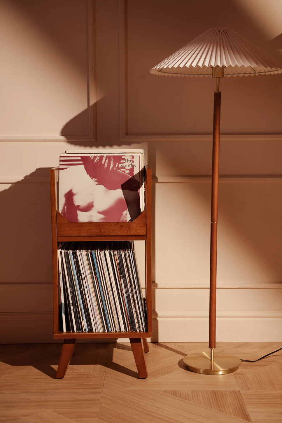 Crosley Asheville walnut vinyl record storage stand displayed in a home entertainment setting