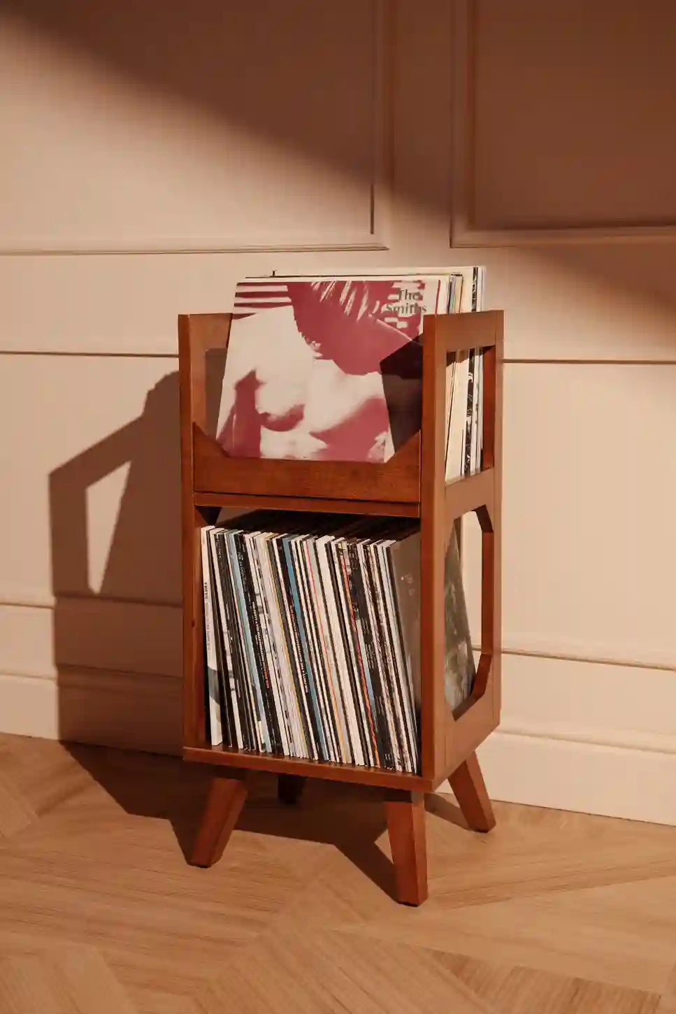 Crosley Asheville small walnut vinyl record storage stand displayed in a home entertainment setting