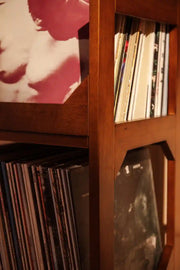 Crosley Asheville small walnut vinyl record storage stand displaying records in a home entertainment setting