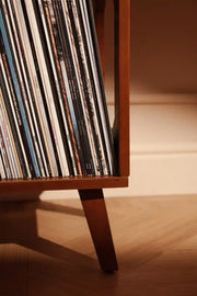Crosley Asheville small walnut vinyl record storage stand displayed in a home entertainment setting