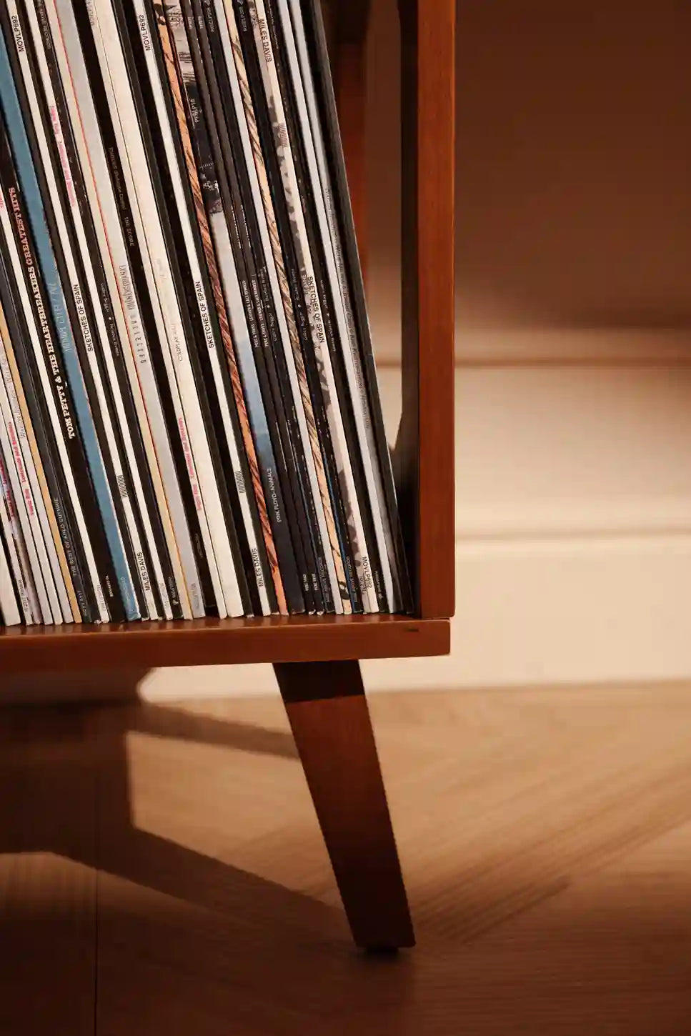 Crosley Asheville small walnut vinyl record storage stand displayed in a home entertainment setting