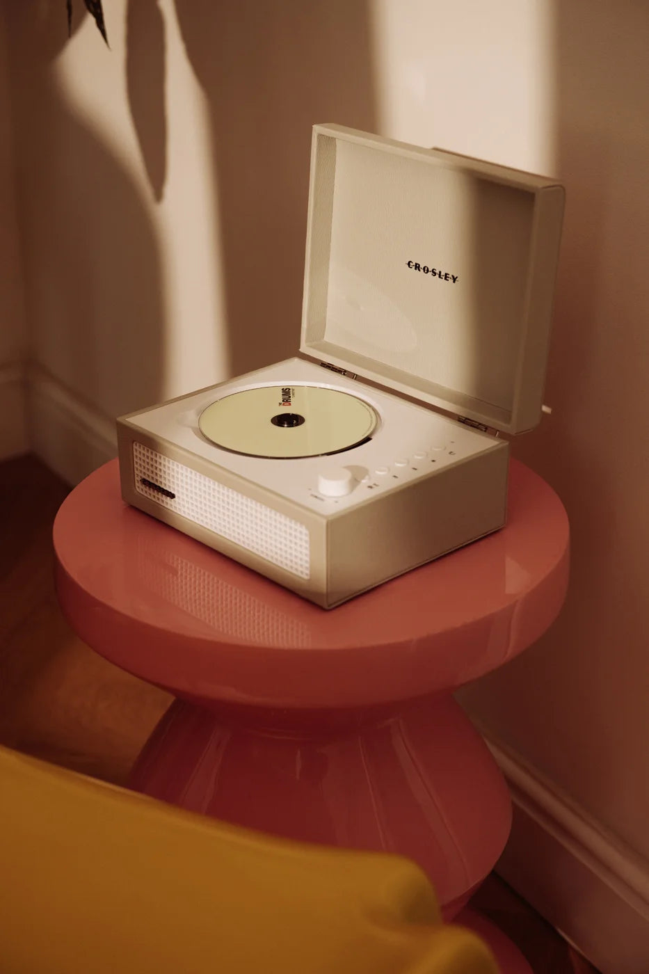 Crosley Voyager dune CD player with Bluetooth and FM radio on white surface with lifestyle setting