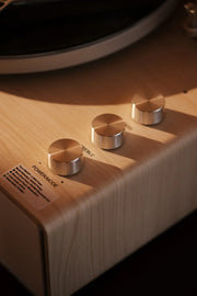Crosley Stave Bluetooth Record Player in natural wood finish displayed in a lifestyle setting